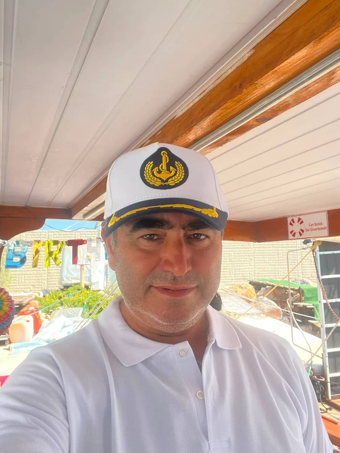 Okan Dörtköşe Okan Kaptan teknesinde kaptan kıyafetiyle